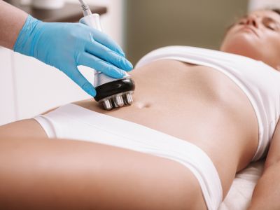 Mujer experimentando un masaje corporal abdominal con un aparato electrónico